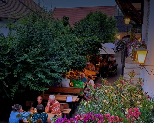 Gemütliche Sitzgelegenheiten im Freien, umgeben von dichtem Laub und Blumen